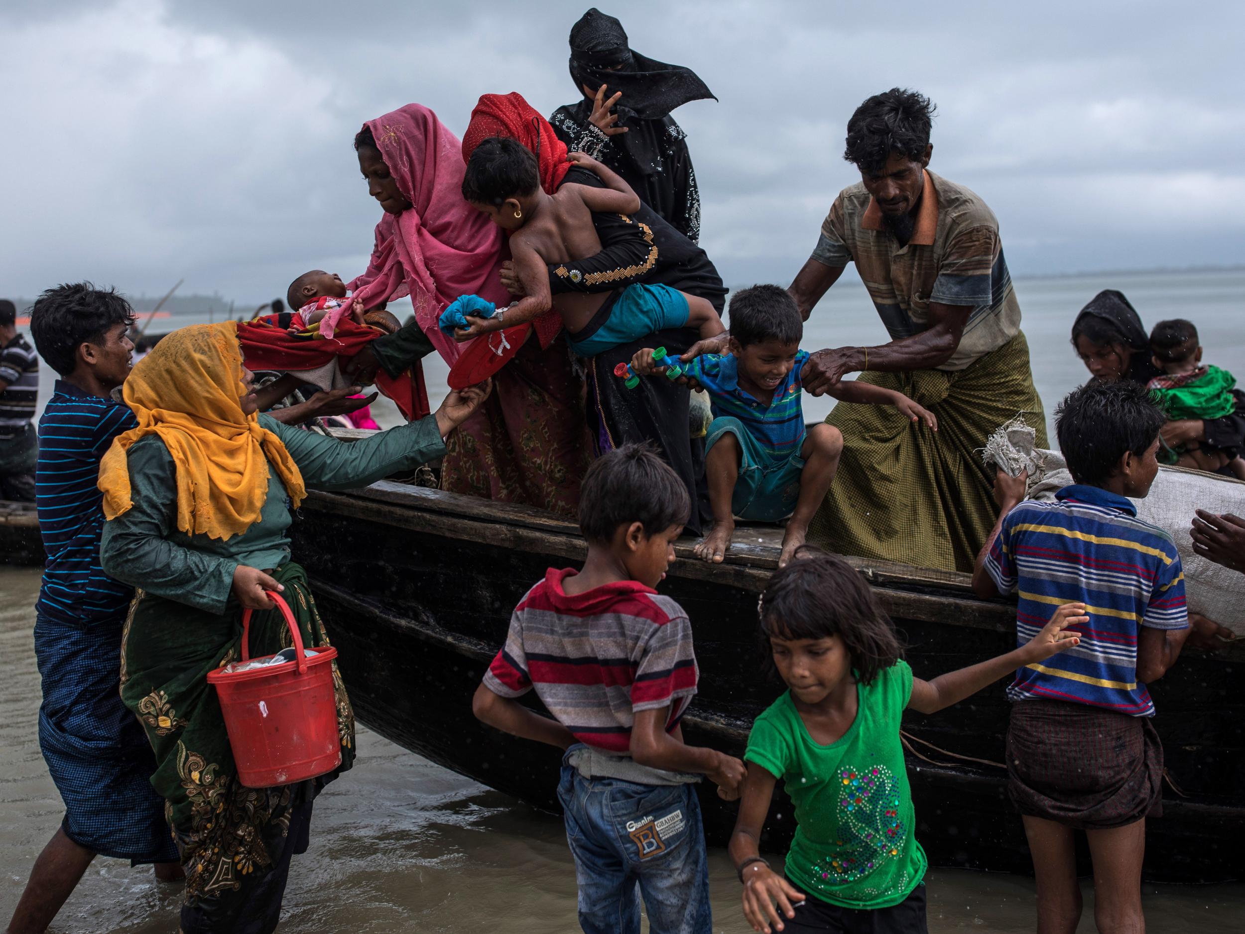 Rohingya Muslim refugees arrive in Bangladesh on a boat after crossing from Burma