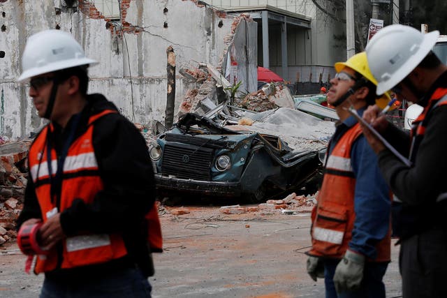 Workers survey the aftermath in Mexico City