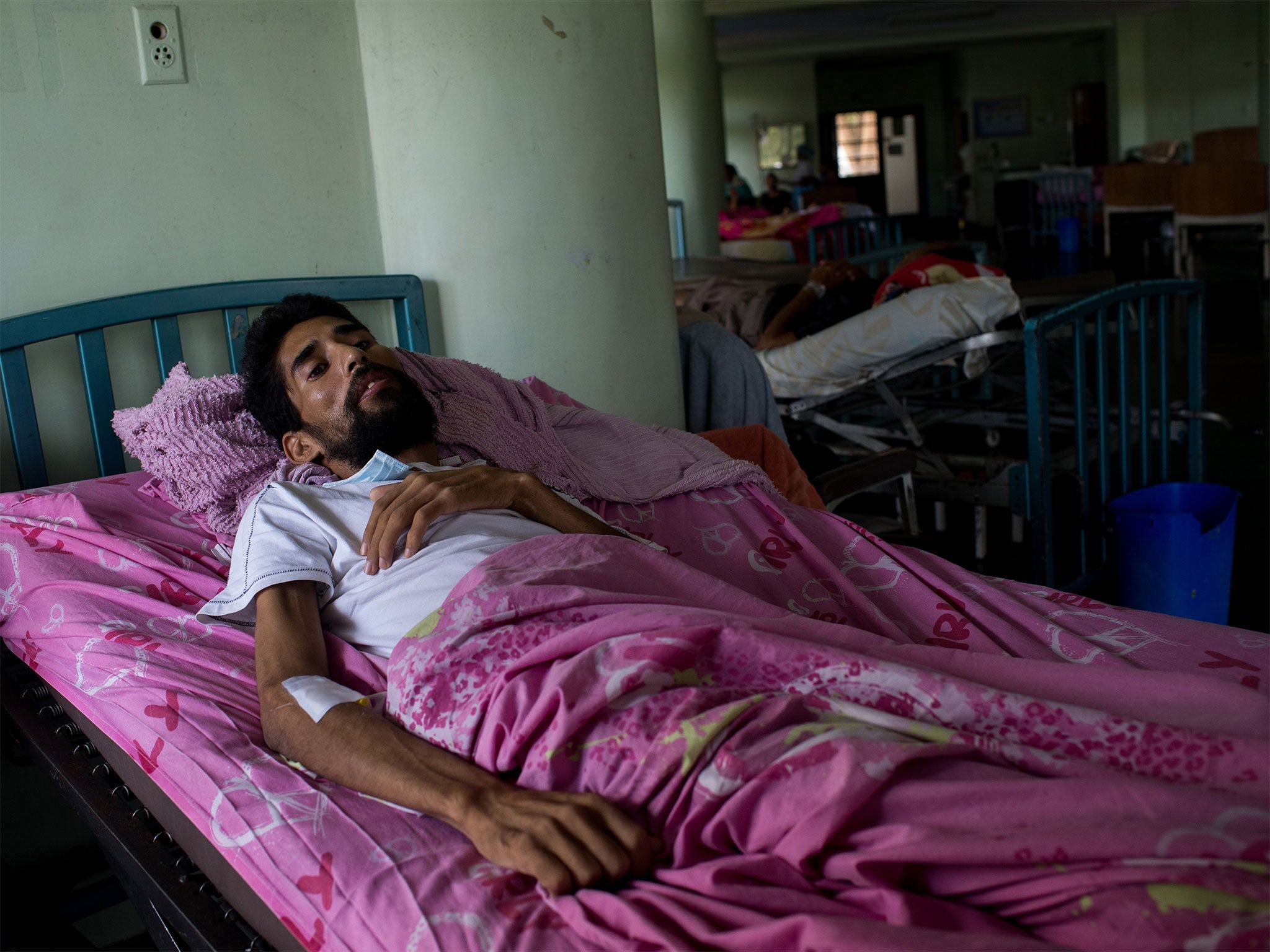HIV patient Jesus Morales lies in bed at Caracas University Hospital