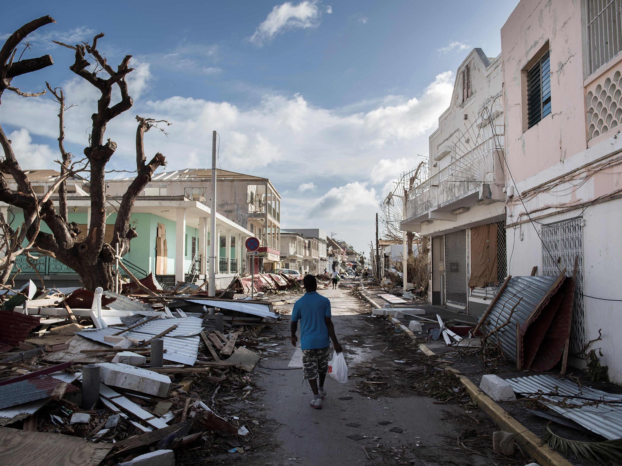 A man walks on a street covered in debris after Hurricane Irma strikes the Saint Martin in the Caribbean in 2017