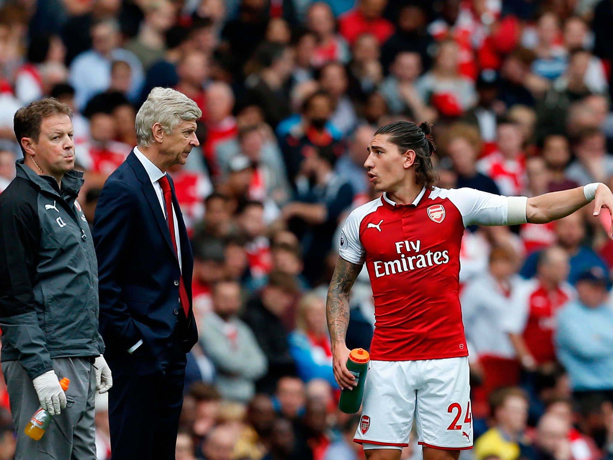 Hector Bellerin and Arsene Wenger exchange a quick word during the first half