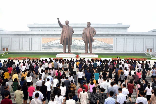 North Korean residents offer flowers before the statues of Kim Il-Sung and Kim Jong-Il during celebrations of the 69th anniversary of North Korea's founding