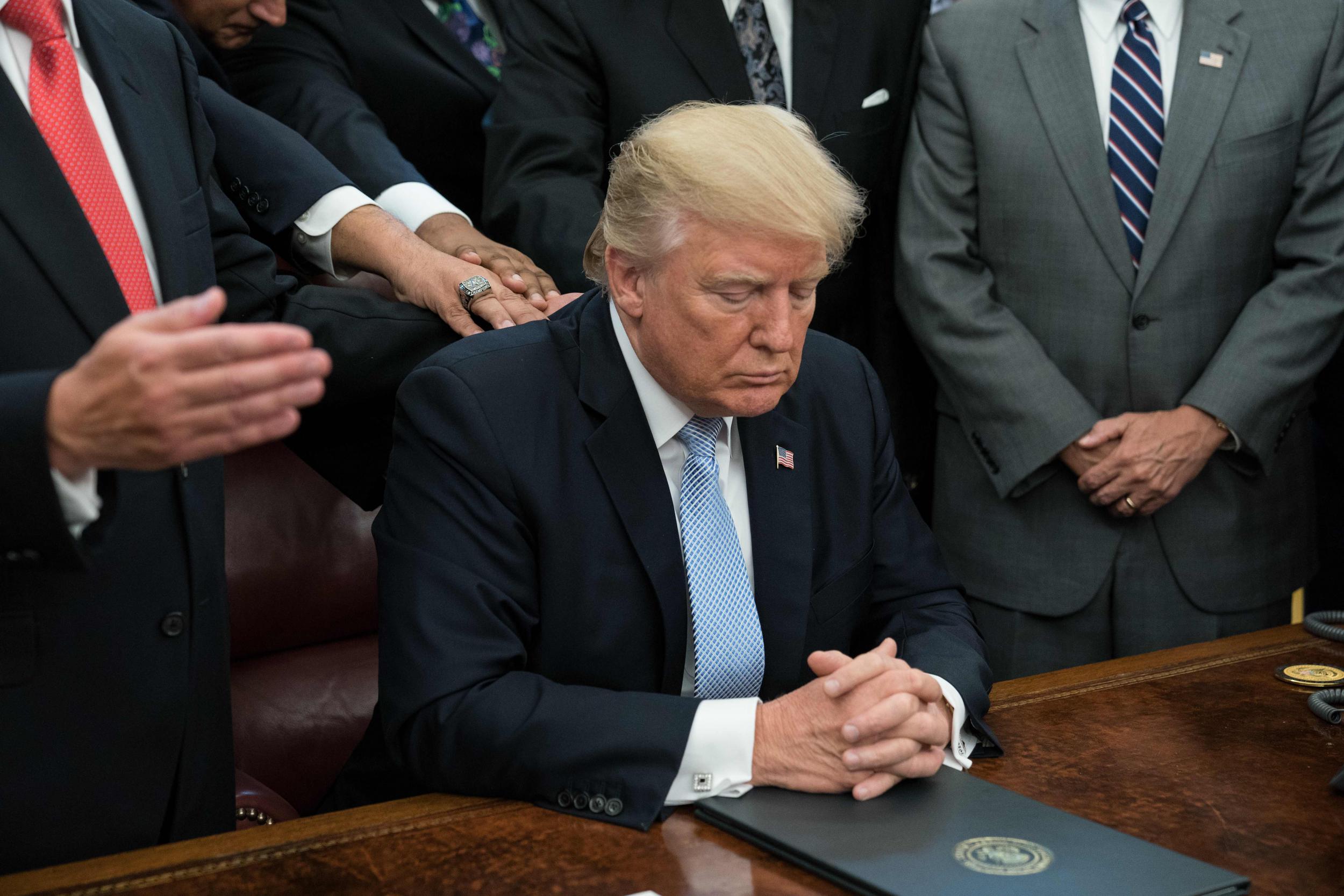 Donald Trump and faith leaders pray in the Oval Office at the White House