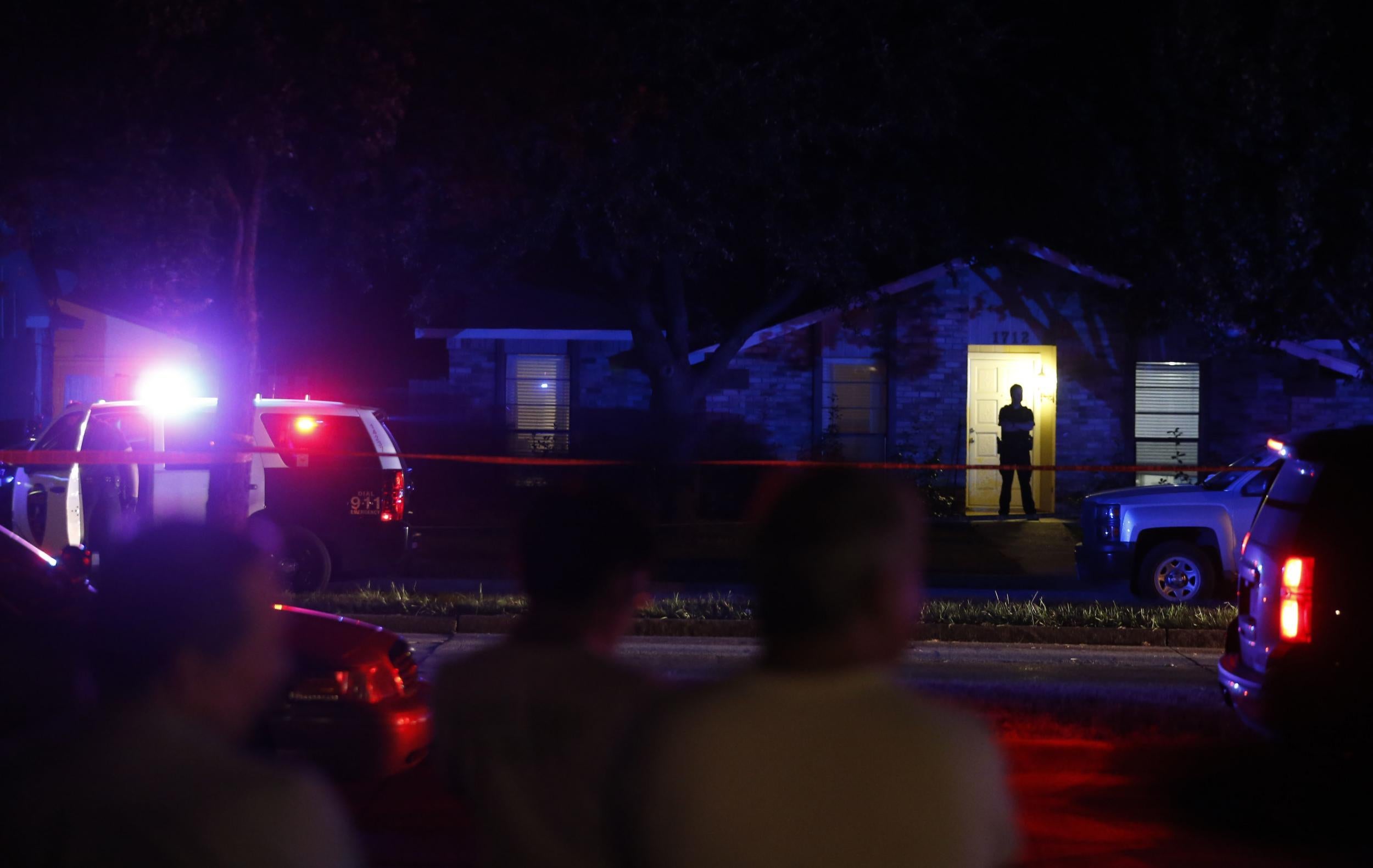 nlookers watch police work the scene of a shooting at a home in Plano, north of Dallas