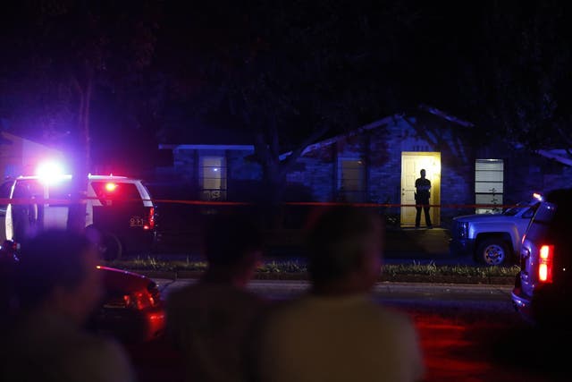 nlookers watch police work the scene of a shooting at a home in Plano, north of Dallas
