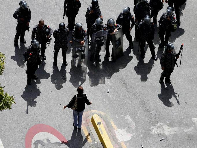 A woman argues with riot police in Caracas, Venezuela, on 4 August 2017