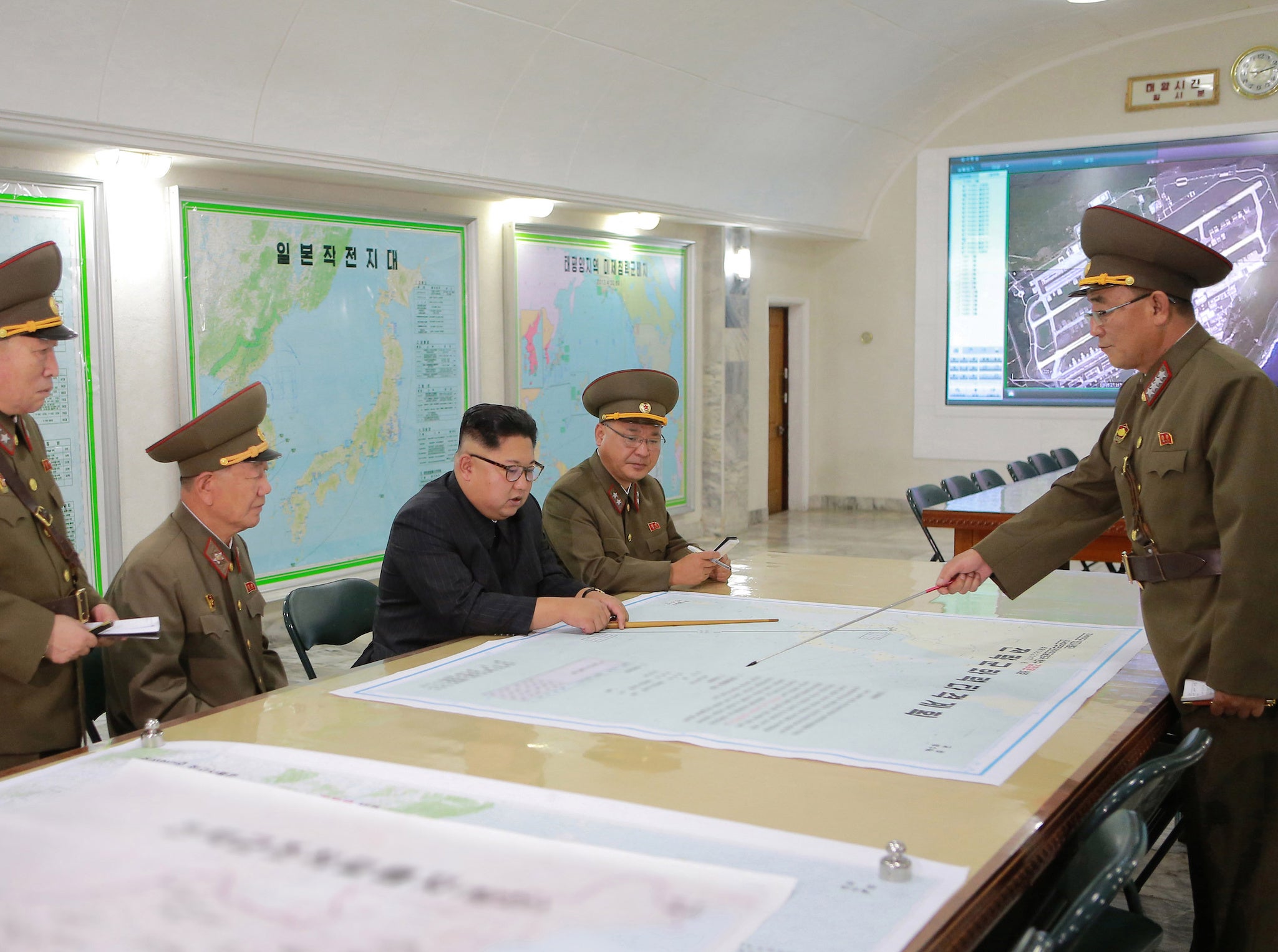 The photo released by KCNA agency appears to show North Korean leader Kim Jong-Un studying an outdated map of Anderson Air Base, Guam