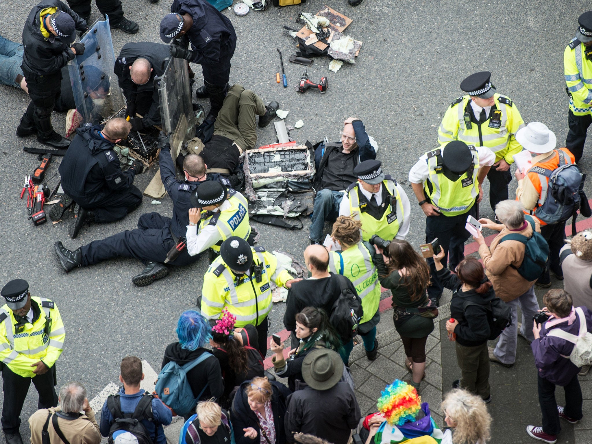 Police work to remove protesters who blocked an access road to the 2017 Defence and Security Equipment International (DSEI) arms fair by chaining themselves together on 6 September 2017