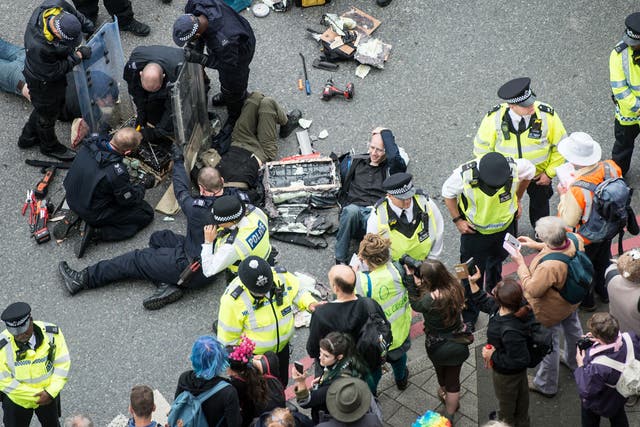 <p>Police work to remove protesters who blocked an access road to the 2017 Defence and Security Equipment International (DSEI) arms fair by chaining themselves together on 6 September 2017</p>