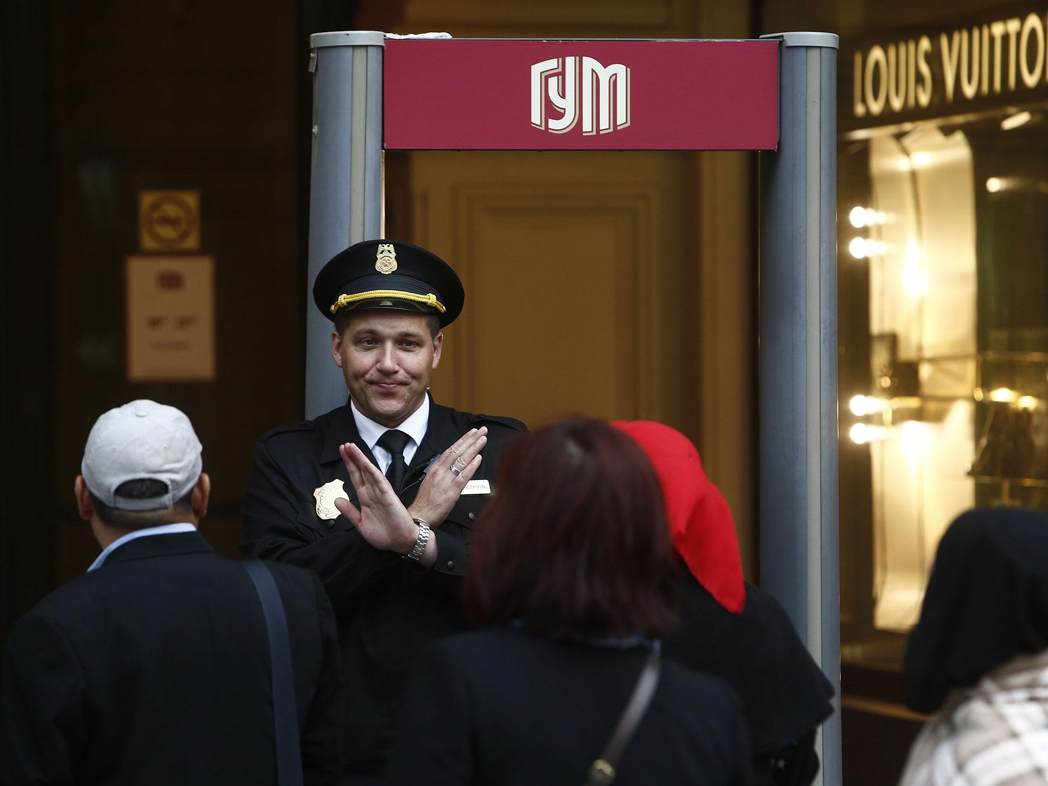 A security guard blocks the entrance to the State Department Store, GUM, due to a bomb threat in central Moscow