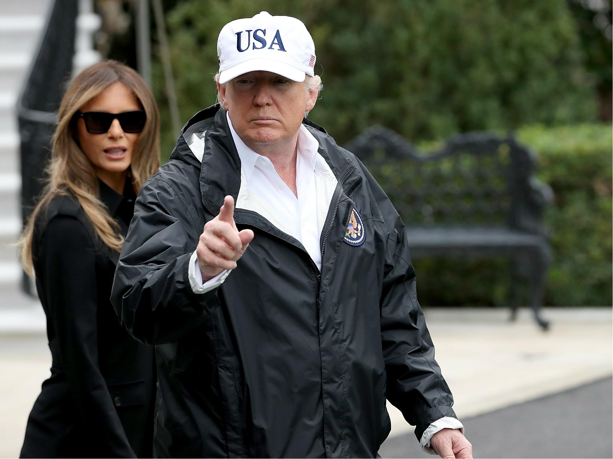 Donald Trump, with first lady Melania Trump, gestures as he answers questions while departing the White House for Florida on 14 September 2017