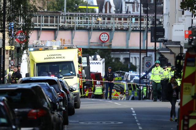 Police, fire and ambulance crew attend to the attack at Parsons Green underground station
