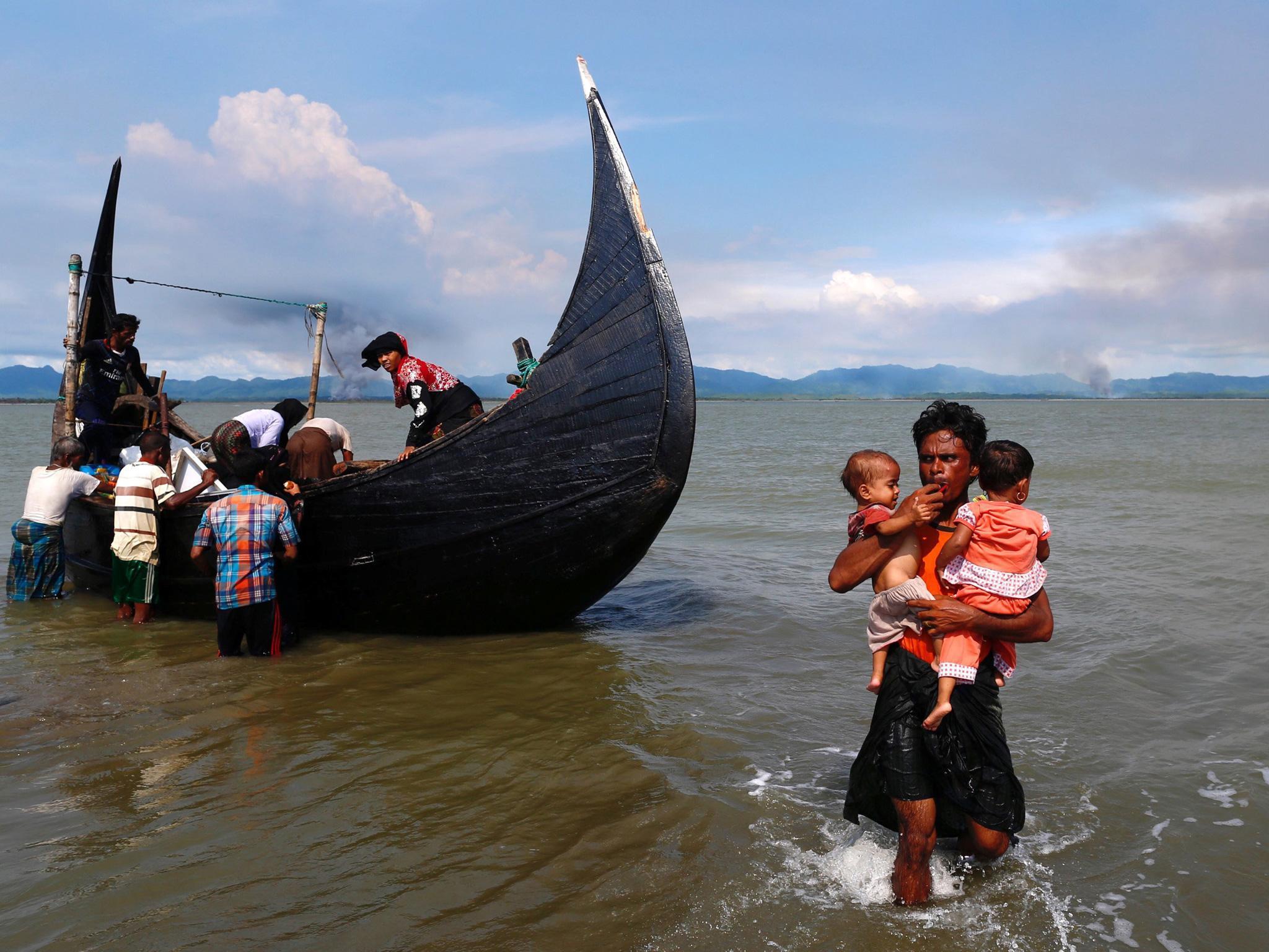 Smoke rises on Burma's side of the border, as Rohingya refugees complete the crossing into Bangladesh