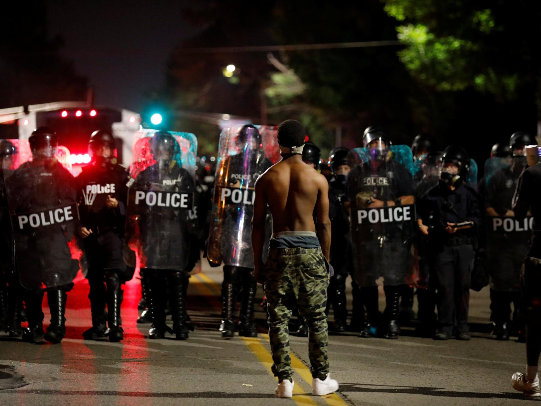 A protester faces off with law enforcement officials during Friday’s protests in St Louis