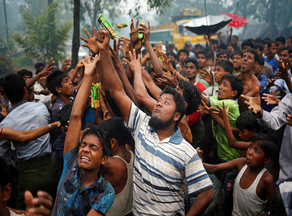 Rohingya refugees try to grab handouts as they are thrown from trucks