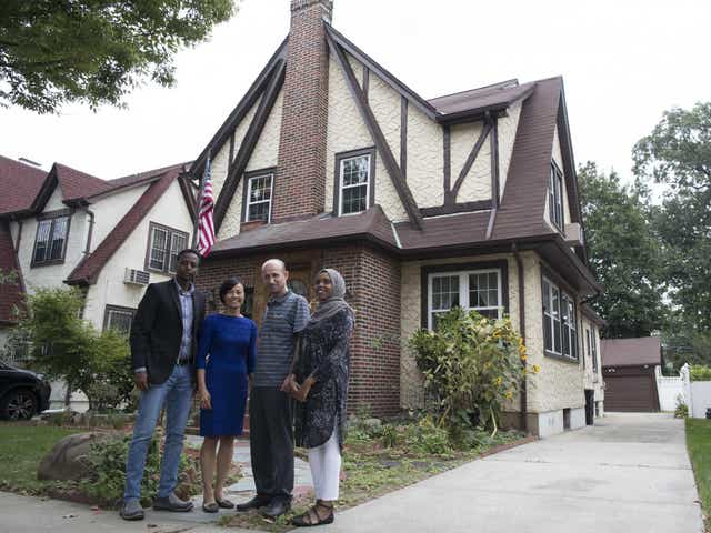 Abdi Iftin (left) from Somalia, Uyen Nguyen (second from left) of Vietnam, Eiman Al (right) of Somalia but born in Yemen and Ghassan al-Chahada, of Syria, pose for a photo outside President Donald Trump's boyhood home in the Jamaica Estates neighbourhood of the Queens borough of New York