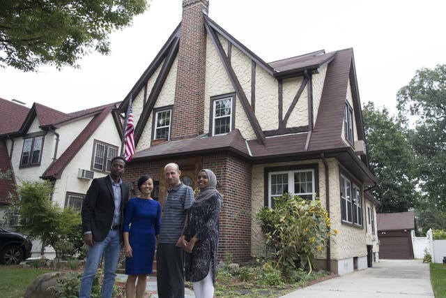 Abdi Iftin (left) from Somalia, Uyen Nguyen (second from left) of Vietnam, Eiman Al (right) of Somalia but born in Yemen and Ghassan al-Chahada, of Syria, pose for a photo outside President Donald Trump's boyhood home in the Jamaica Estates neighbourhood of the Queens borough of New York