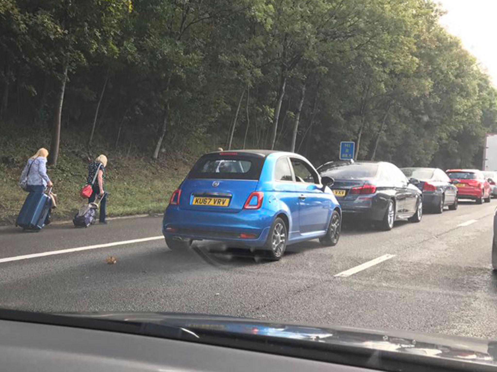 Photos shared on social media showed long traffic queues and people walking along the hard shoulder with their suitcases