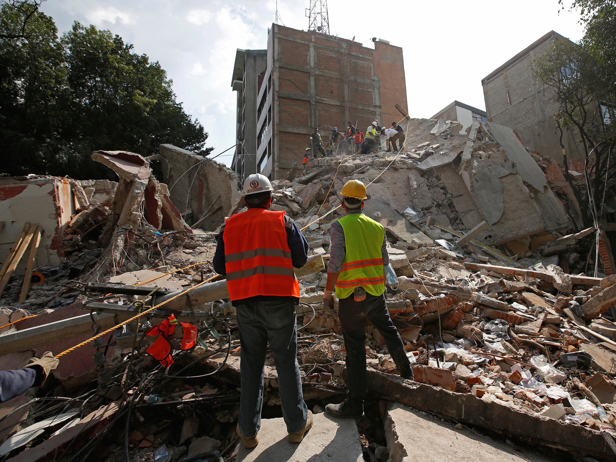 Rescue workers search for people under the rubble of a collapsed building after an earthquake hit Mexico City