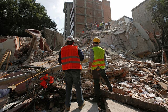 Rescue workers search for people under the rubble of a collapsed building after an earthquake hit Mexico City