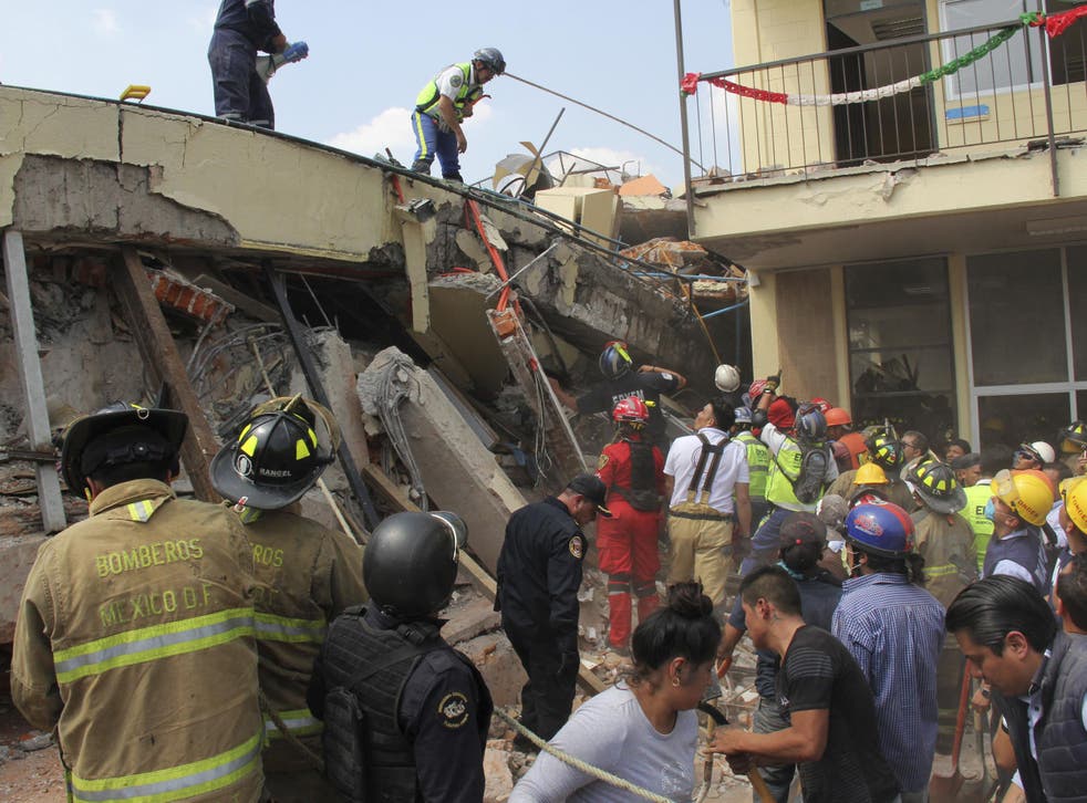 Rescue workers search for children trapped inside the collapsed Enrique Rebsamen school in Mexico City
