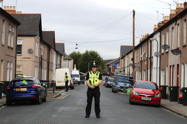 A police officer stands about a cordon near a home being searched in relation to the Parsons Green attack on 20 September in Newport, Wale