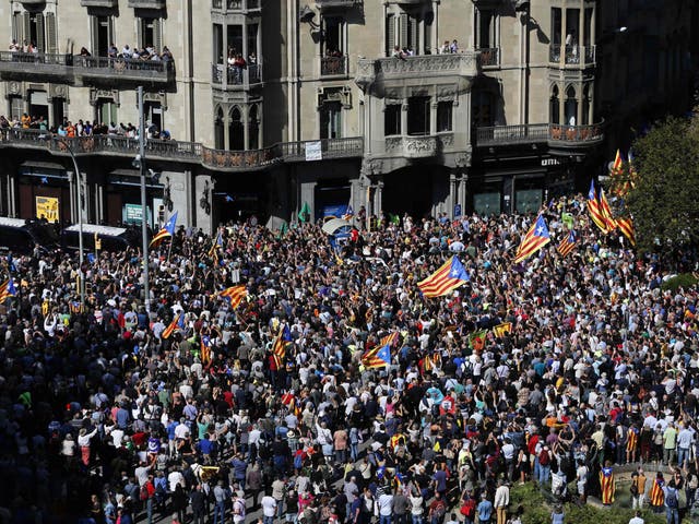 People holding 'Esteladas' (Catalan pro-independence flags) attend a protest near the Economy headquarters of Catalonia's regional government in Barcelona