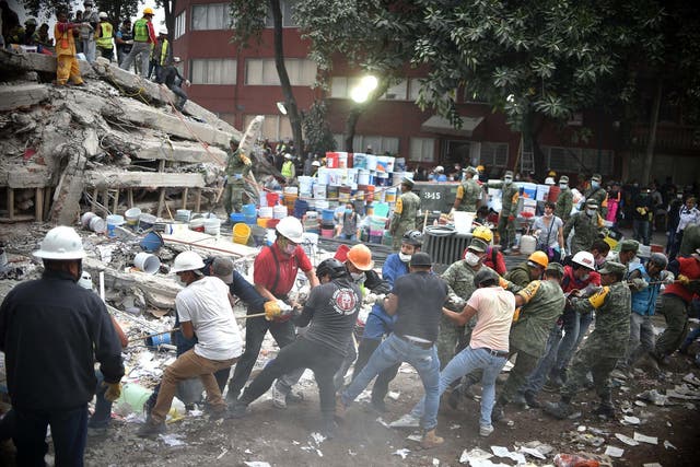 Rescuers, firefighters, policemen, soldiers and volunteers search for survivors in a flattened building in Mexico City
