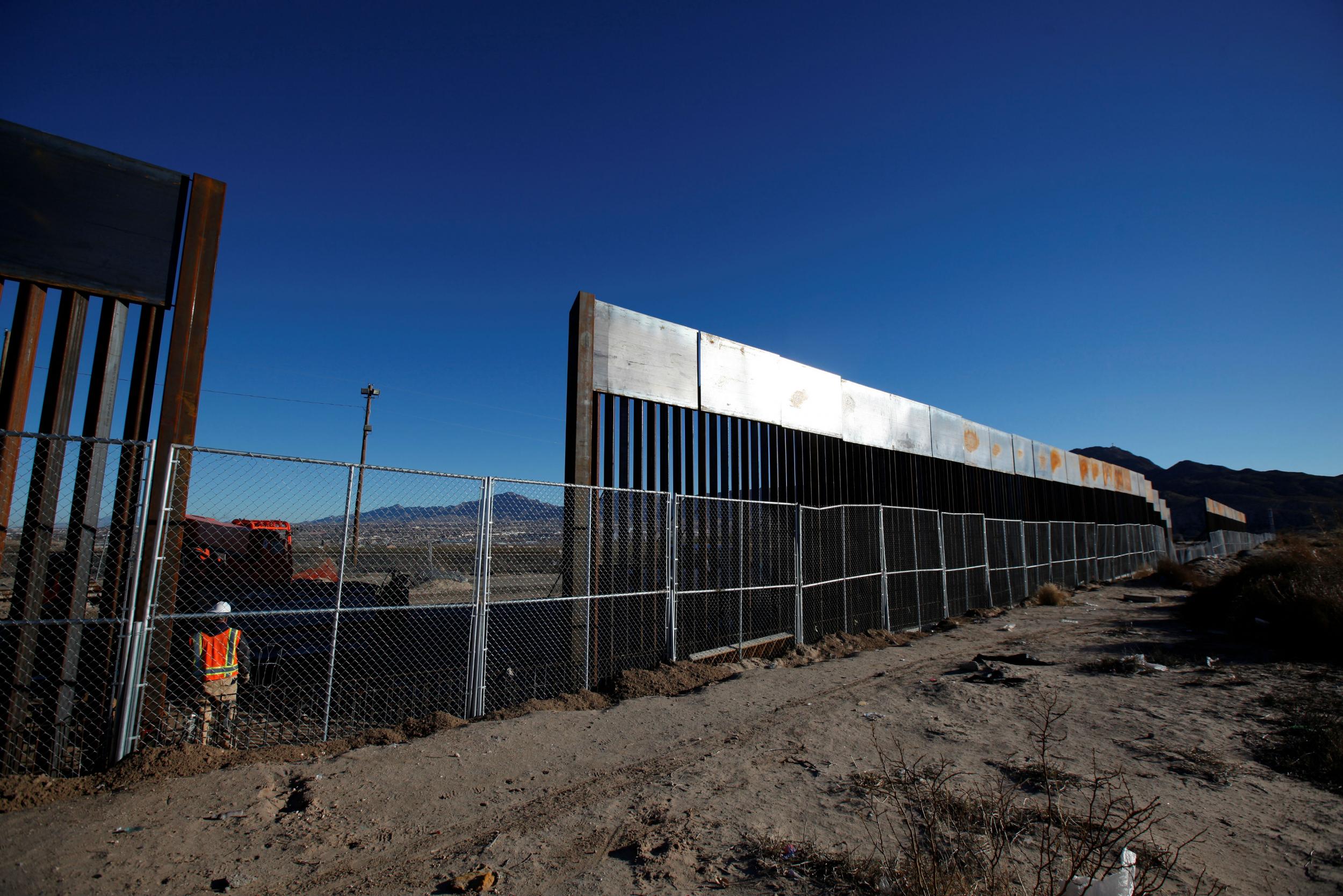 A worker stands next to a newly built section of the U.S.-Mexico border fence at Sunland Park, U.S. opposite the Mexican border city of Ciudad Juarez, Mexico.