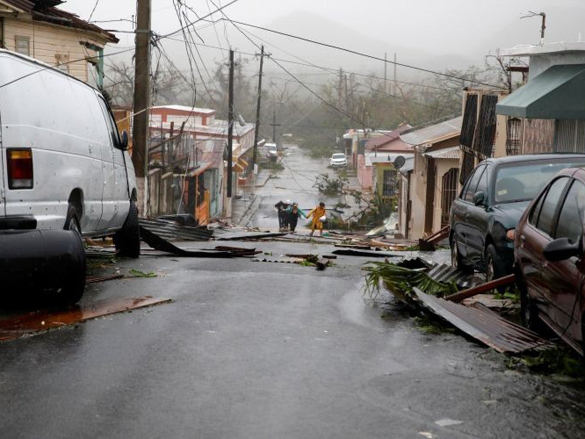 People walking amongst the debris in the Puerto Rican town of Guayama