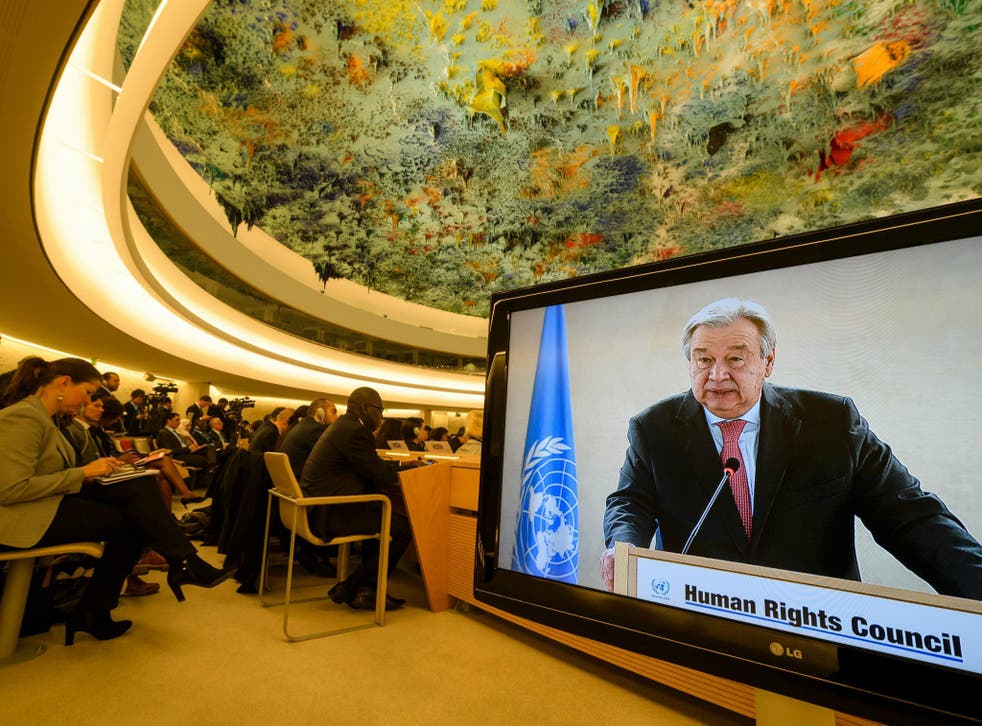 UN Secretary-General Antonio Guterres is seen on a TV screen while addressing the United Nations Human Rights Council in Geneva. Nine members of the Council have been found as human rights violators.