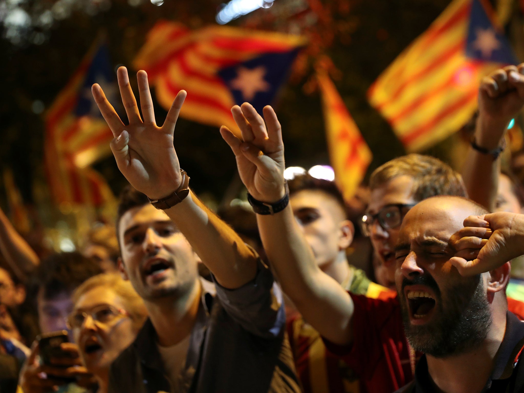 Protesters sing as they gather outside the Catalan region's economy ministry building during a raid by Spanish police on government offices, in Barcelona