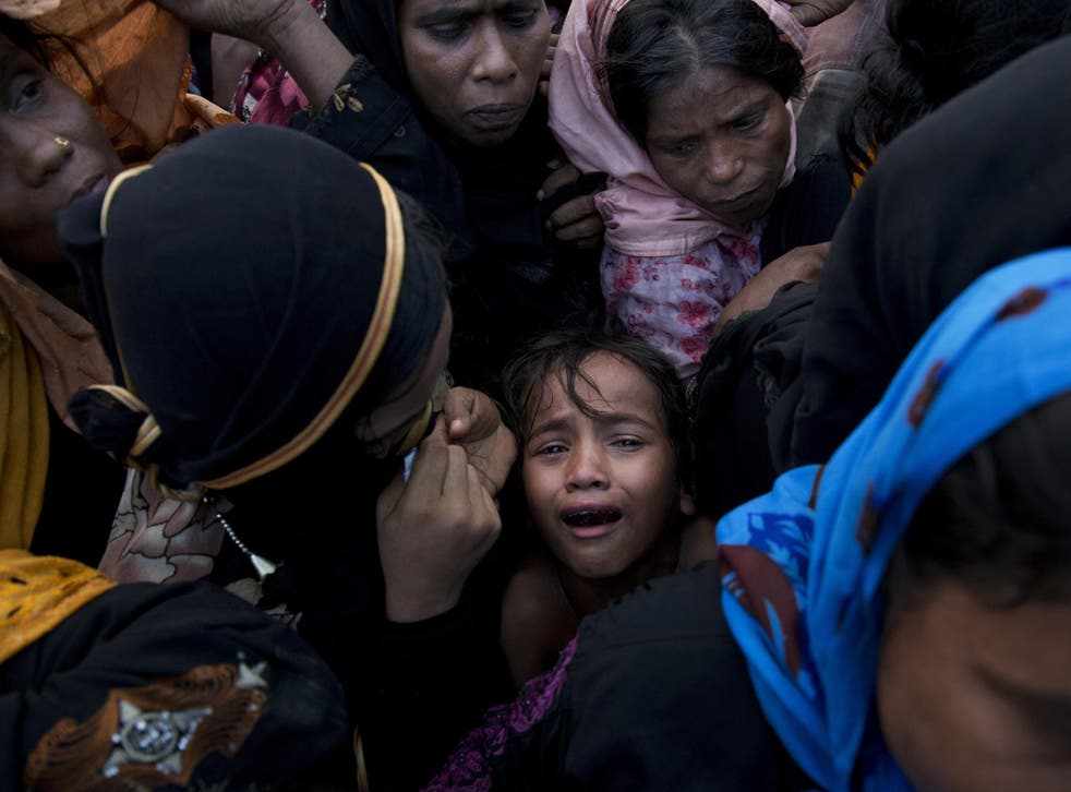A Rohingya Muslim child cries as she stands amid a crowd of elders to receive food being distributed near Balukhali refugee camp in Cox's Bazar, Bangladesh