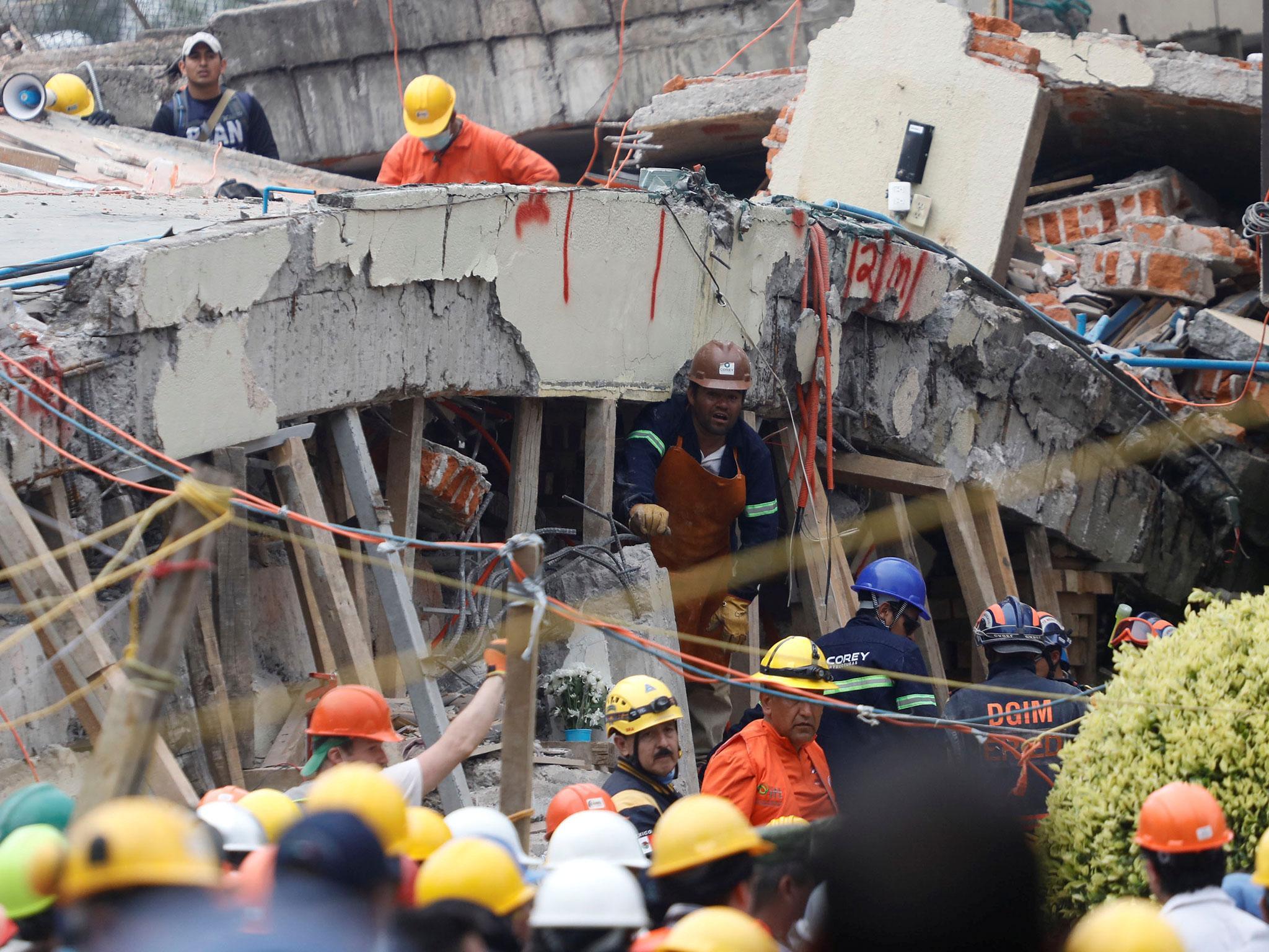 Rescue workers search through the rubble for students at Enrique Rebsamen school after an earthquake in Mexico City