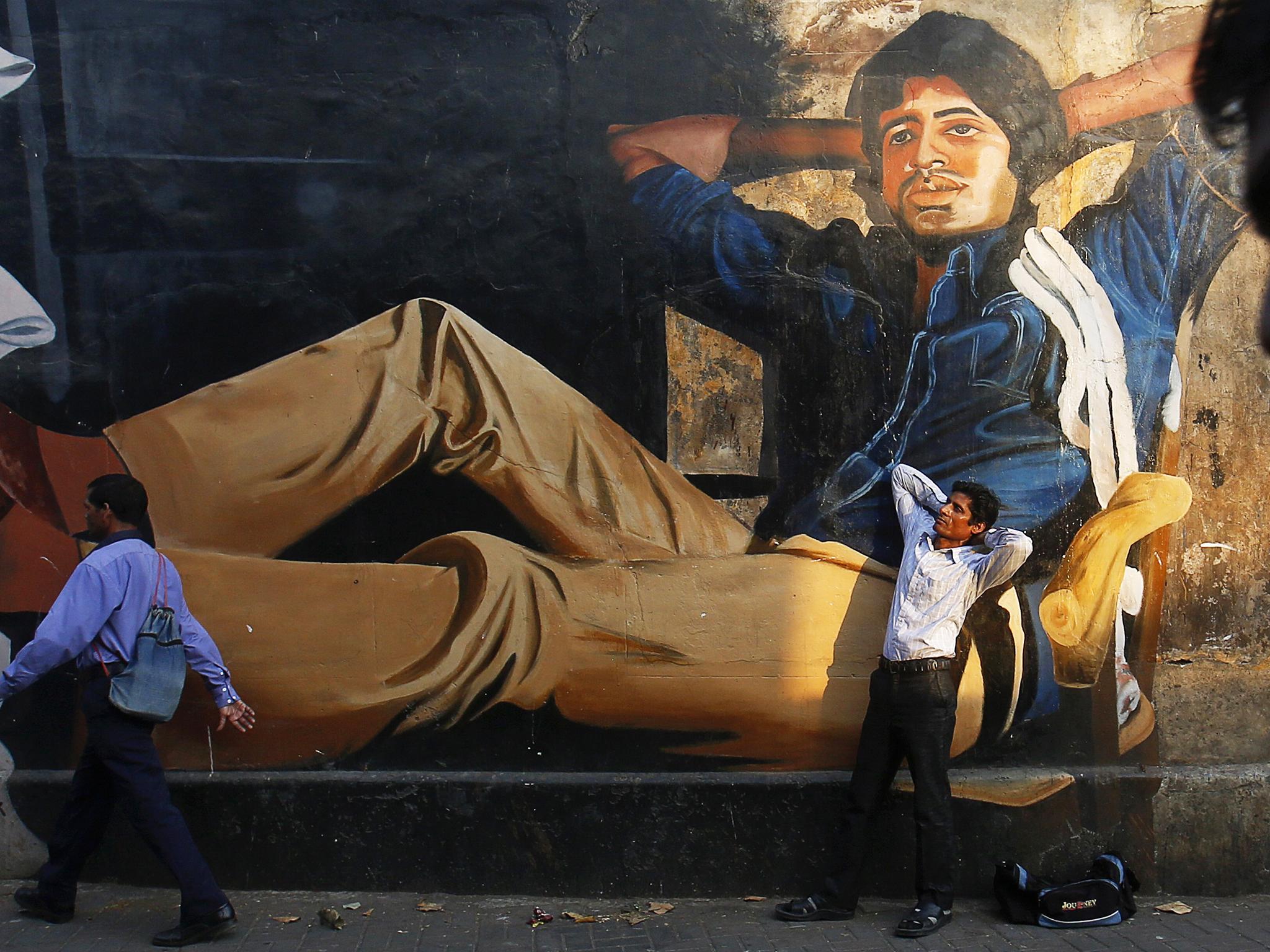The 32-year-old aspiring film actor, poses in front of a mural of actor Amitabh Bachchan