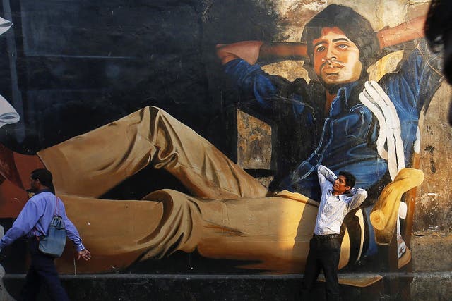 The 32-year-old aspiring film actor, poses in front of a mural of actor Amitabh Bachchan
