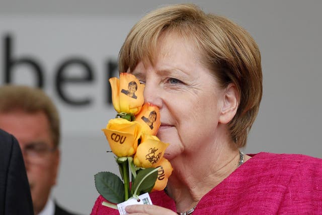 Angela Merkel smells some Christian Democratic Union (CDU) branded flowers at an election campaign event in Heppenheim