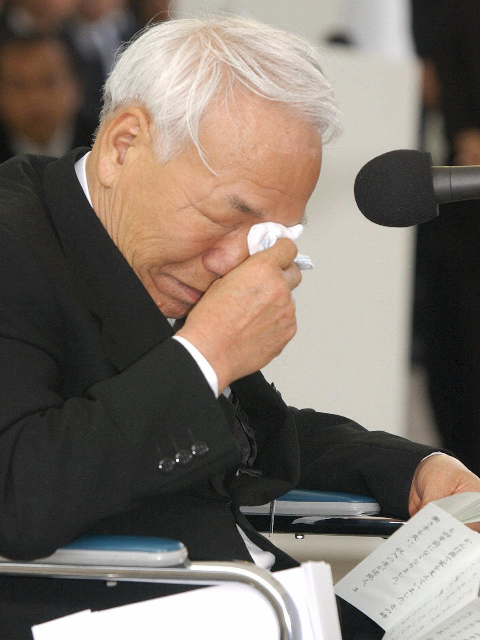 Tsuginori Hamamoto, a patient with Minamata disease, wipes away tears after speaking at a memorial service marking the 50th anniversary of health disaster