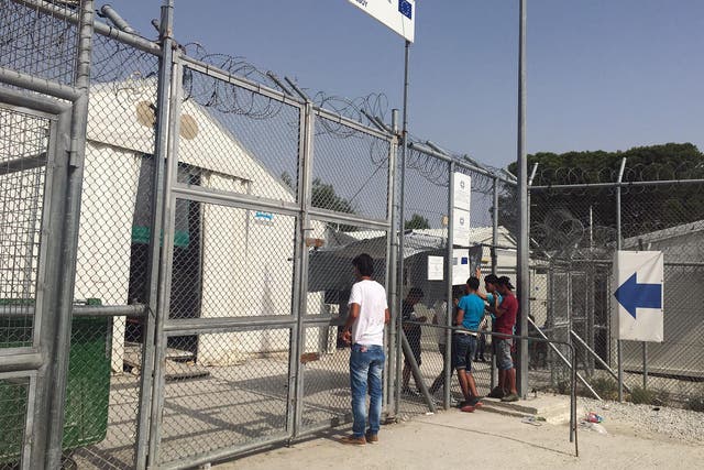 Refugees at the Moria camp wait outside the gates of the onsite detention camp, where others are being held