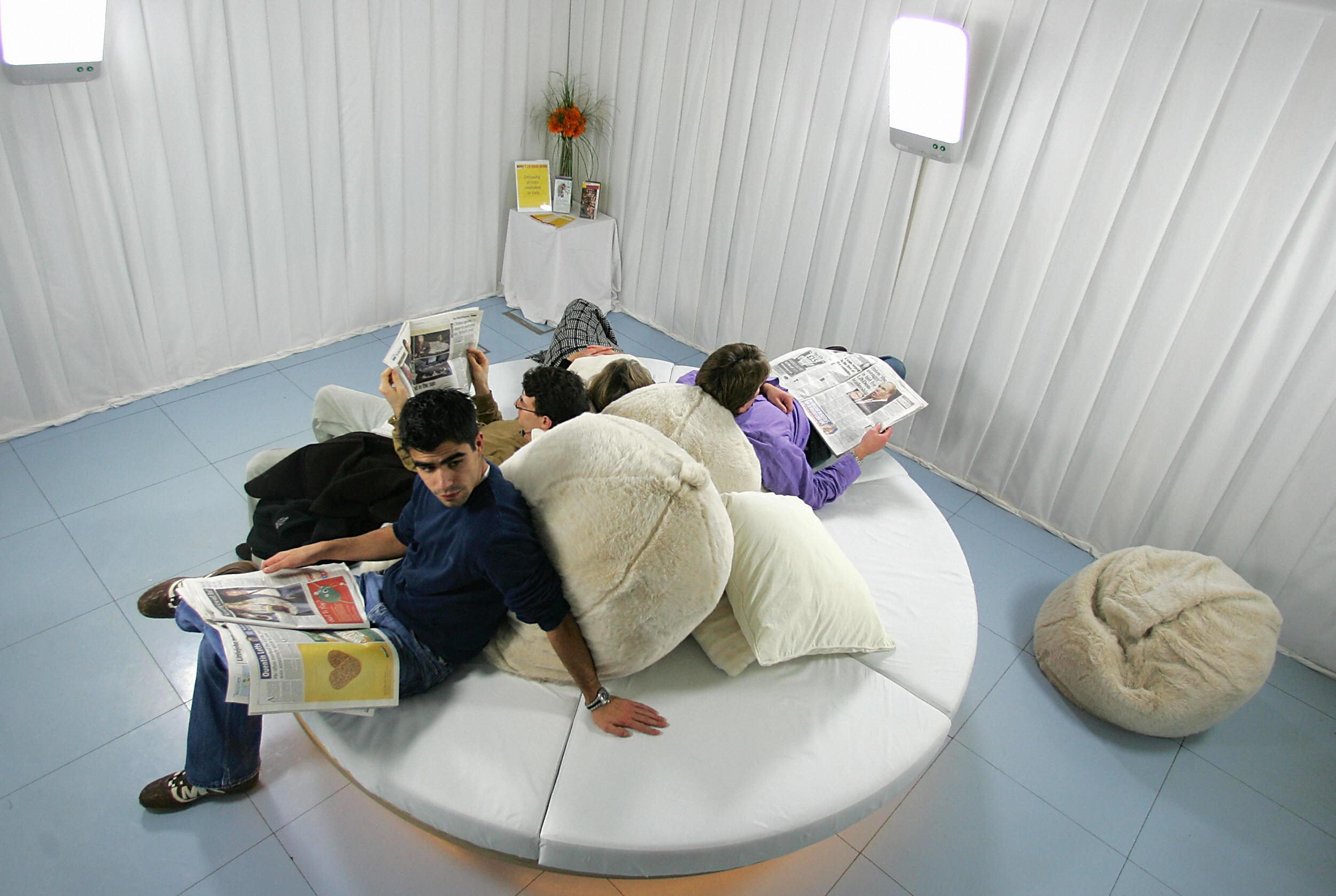 Visitors sit in the new Light Lounge, an ambient white space containing four specially designed light boxes where visitors can relax and have light therapy, in the Science Museum's Dana Centre in London