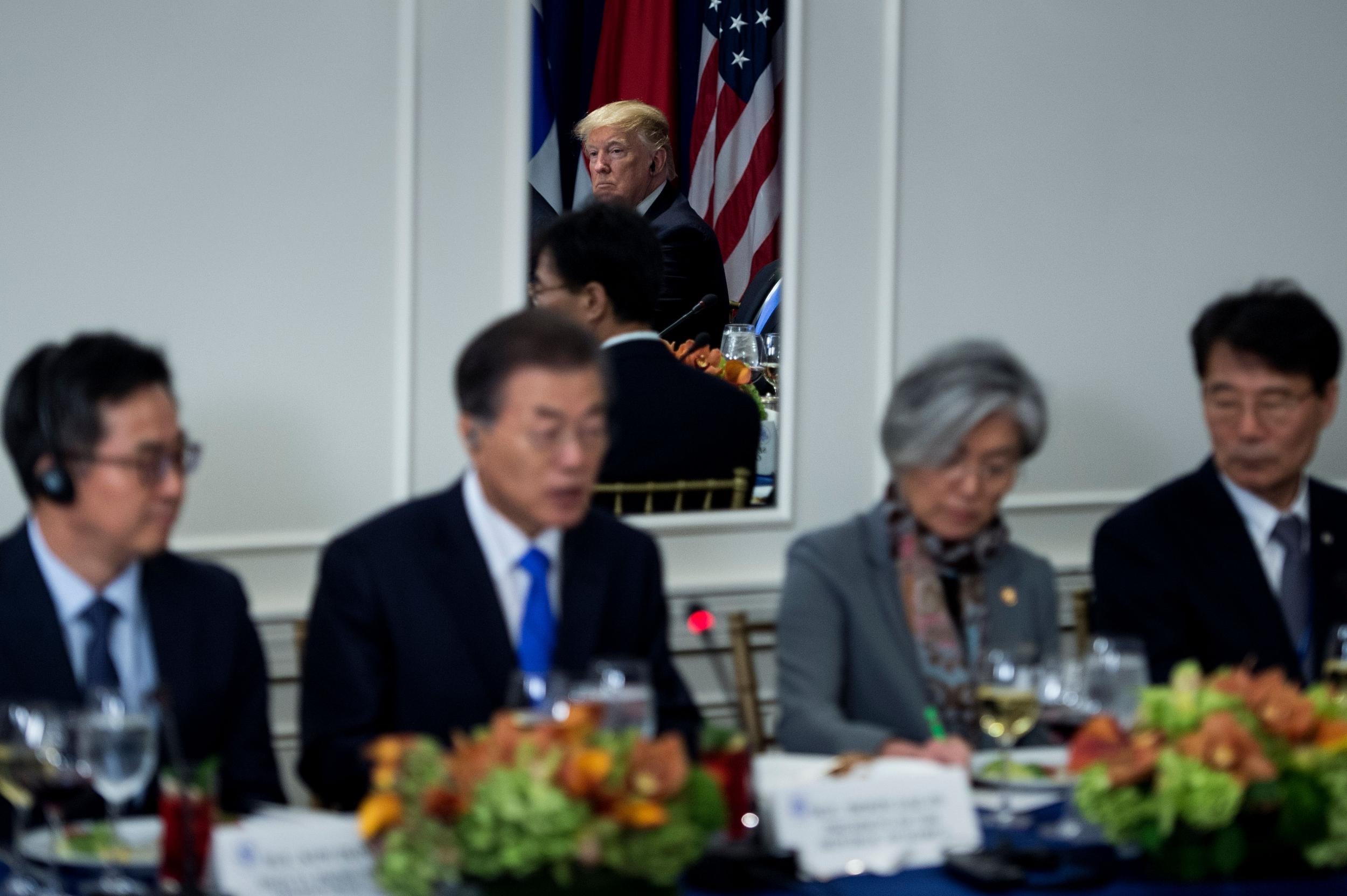 Mr Trump is seen in a mirror listening while South Korea's President Moon Jae-in speaks before luncheon between US, Korean and Japanese leaders in New York