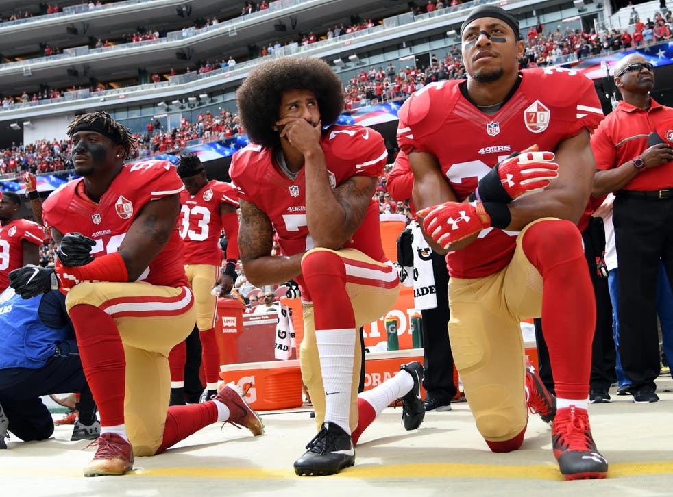 Eli Harold, Colin Kaepernick and Eric Reid of the San Francisco 49ers kneel during the anthem