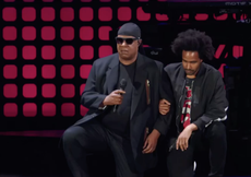 Stevie Wonder takes a knee on stage in protest against Donald Trump