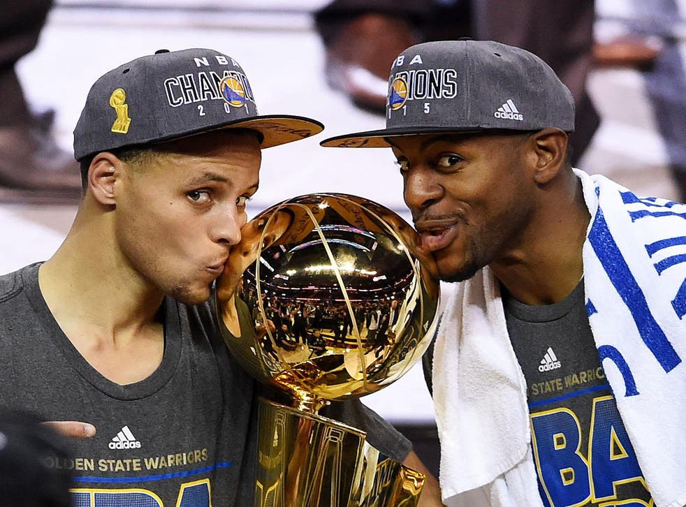 Stephen Curry (l) and Andre Iguodala celebrate with the NBA championship trophy in 2015