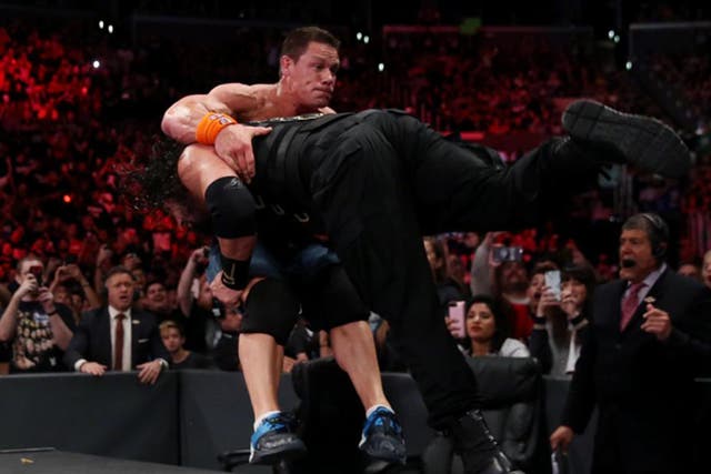 John Cena is speared through the announcers' table by Roman Reigns