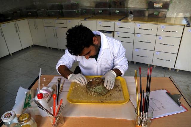 An archaeologist cleans an Assyrian bowl discovered in Iraqi Kurdistan.