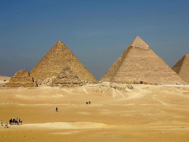 The three large pyramids of Menkaure (L), Khafre (C) and Khufu loom over the horizon at Giza, just outside Cairo, Egypt
