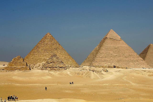 The three large pyramids of Menkaure (L), Khafre (C) and Khufu loom over the horizon at Giza, just outside Cairo, Egypt