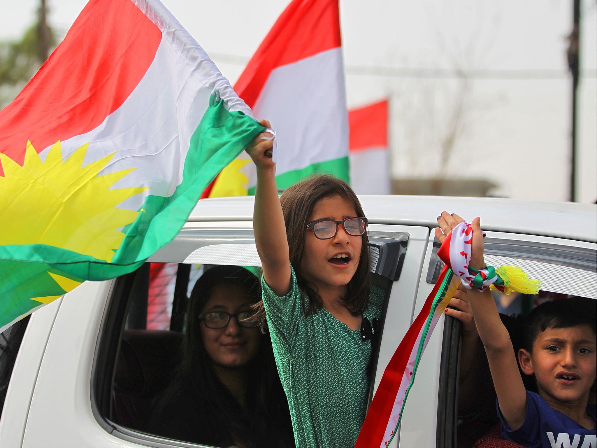 Iraqi children wave Kurdish flags in Kirkuk, but the vote has angered Baghdad and neighbours Turkey and Iran, where many Kurds live