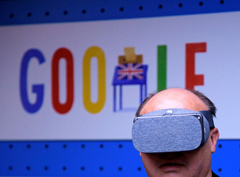 A visitor tries a pair of VR glasses with a smartphone at the Google digital workshop stand at the Labour party Conference in Brighton, Britain, September 24, 2017